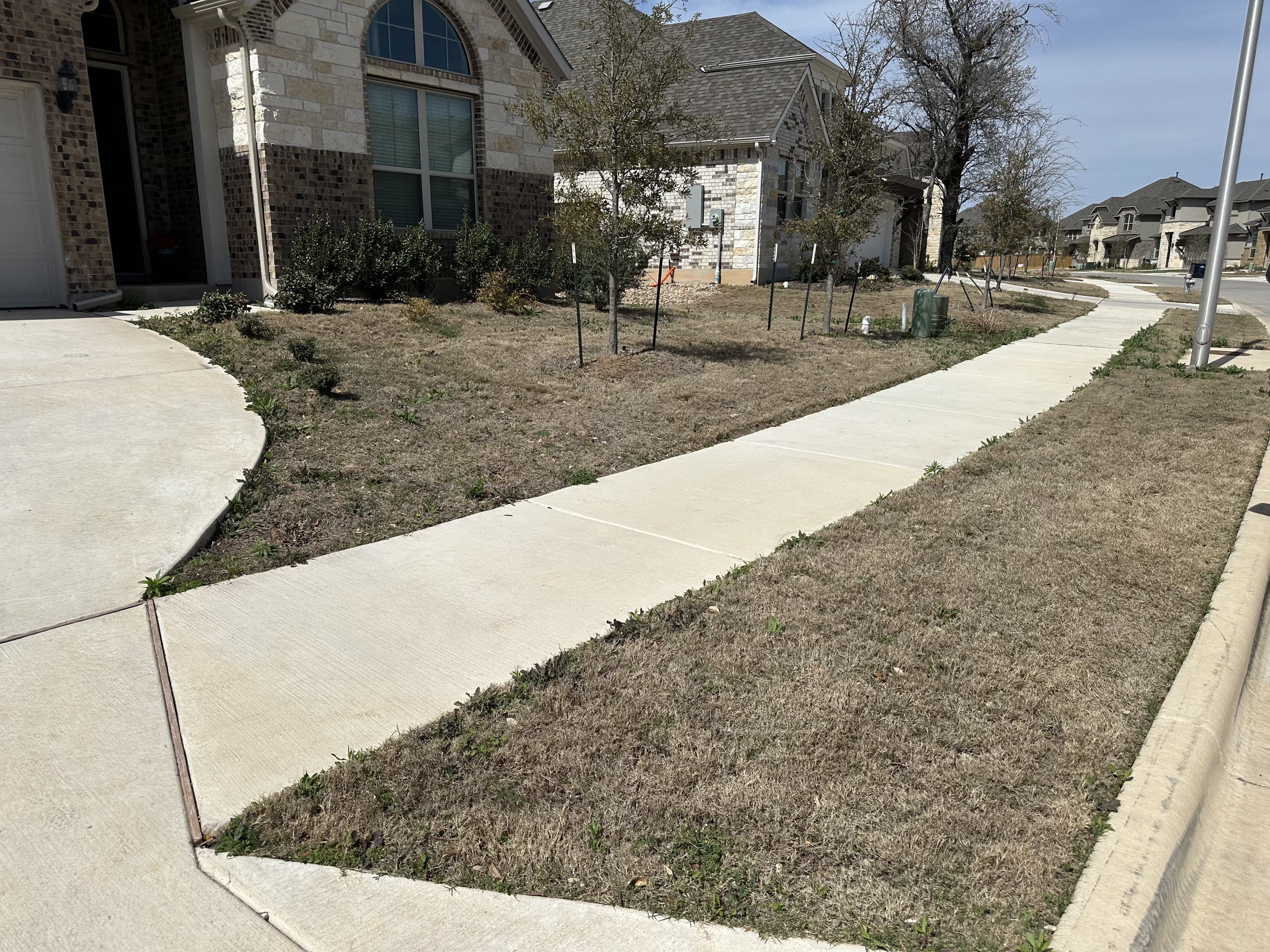 Before - Added new shrubbery to enhance the color as well as a limestone wall to modernize the astetic of the yard and match the house. A fresh layer of black mulch added to retain moisture and to improve the look.